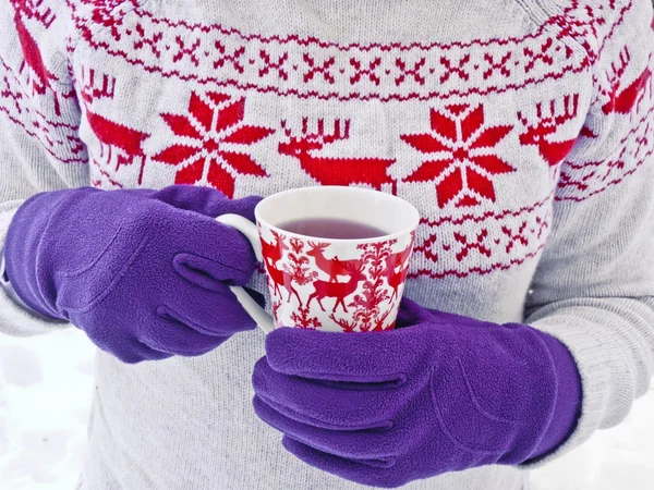 Girl in christmas sweater holding hot tea cup