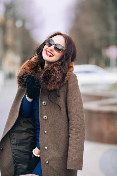 Beautiful Woman in Luxury Fur Coat. Stylish brunette woman in brown coat. young sexy sensual seductive woman with perfect fluffy curled hairs,amazing smile with brilliant white teet, vintage