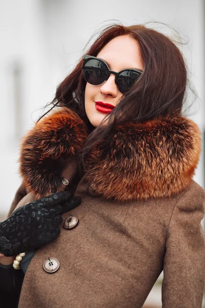Beautiful Woman in Luxury Fur Coat. Stylish brunette woman in brown coat. young sexy sensual seductive woman with perfect fluffy curled hairs,amazing smile with brilliant white teet, vintage