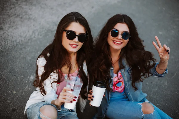 Best friend having fun on the roof, freaking out together, wearing bright floral shirts, denim jackets and mirrored glasses show a sign of peace, enjoy vacation.