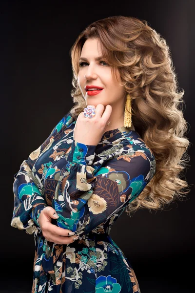Portrait of beautiful woman with magnificent curly hair, trendy jewelry,stylish clothing. Jewelry: ring, earrings. Jewelry.