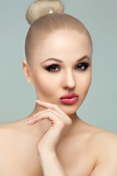 Close-up portrait of a beautiful blonde woman, eyes closed, bright luxury evening make-up. White teeth,plump lips. To touch the mouth. A French manicure.