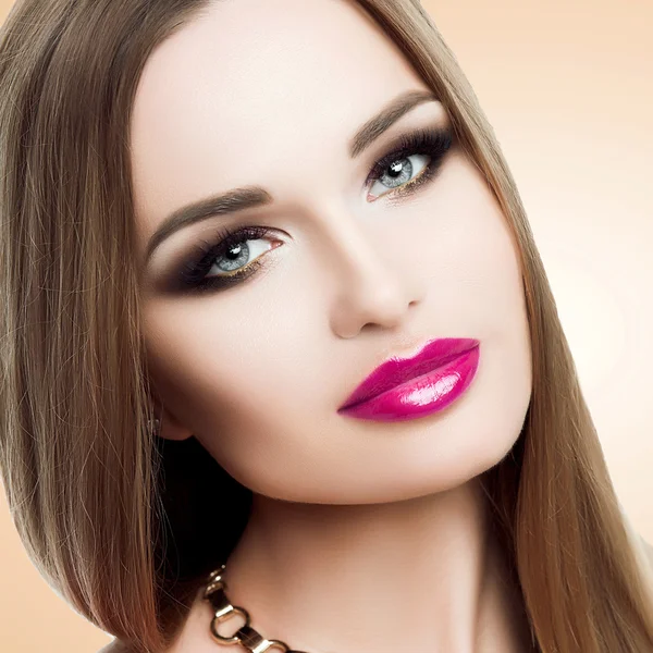 Beauty portrait of beautiful lady with bright makeup, gold, bright fuchsia lips. Beauty, fashion, grooming. Stylish makeup, long eyelashes, look in the camera.
