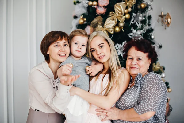 Christmas, x-mas, winter, happiness concept - smiling happy family: grandmother, mother, daughter, granddaughter