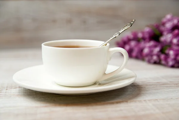 A cup and saucer with a drink on the table