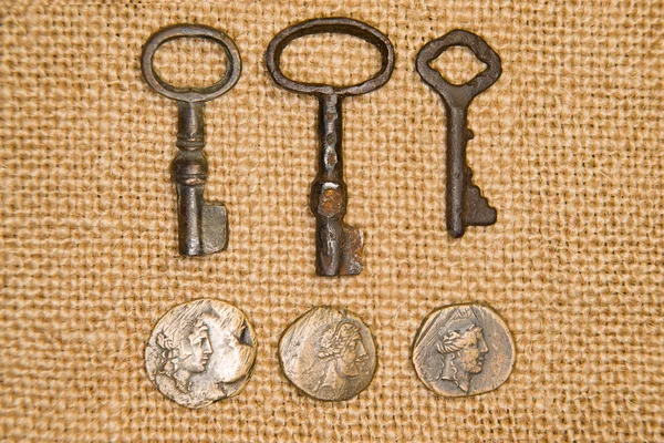 A lot vintage keys from the locks and coins on old cloth