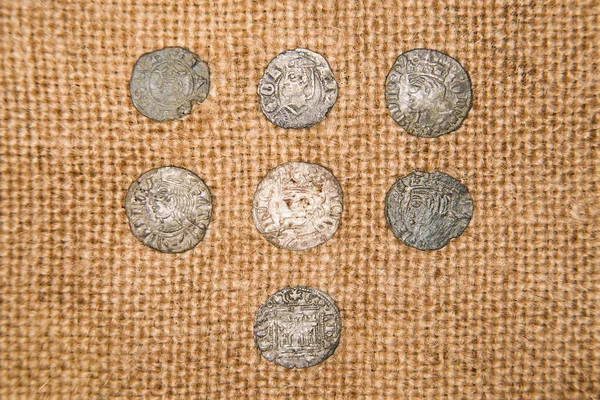 Vintage silver coins with portraits on the old cloth