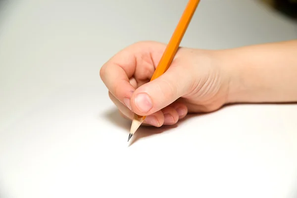 Kid\'s right hand holding a pencil on over white