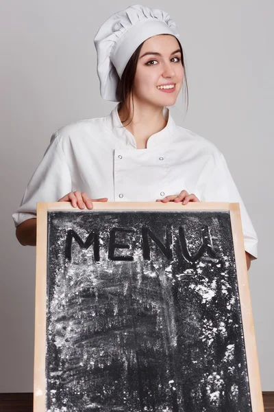 Chef. Woman cook showing empty menu chalkboard with copy space