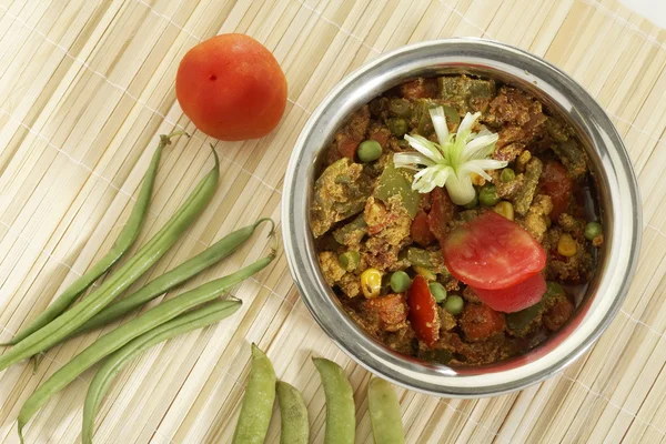 Indian vegetarian dish Mix vegetable in steel pot with raw vegetables.
