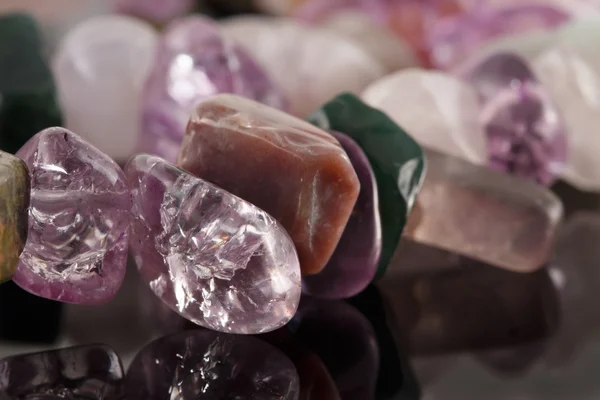 Closeup crystals of amethyst, fluorite, jasper and rose quartz on black table. Selective Focus