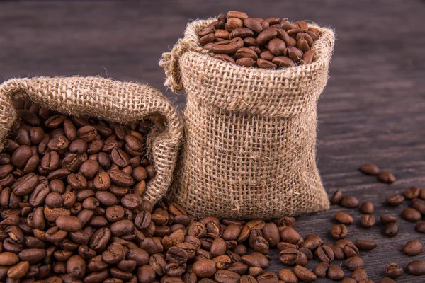 Coffee grains in bags with the scattered grains close up