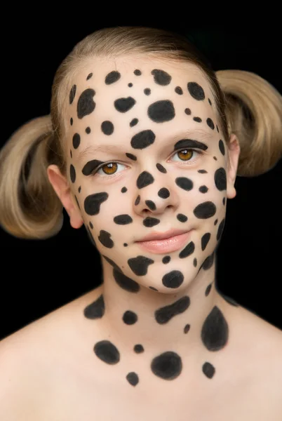 Girl\'s face with spots of a dalmatian and tails on a black background