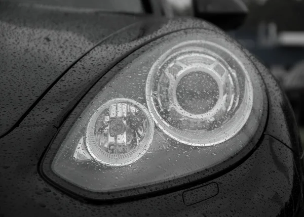 Rain drops on car headlights after water protection repellent coating