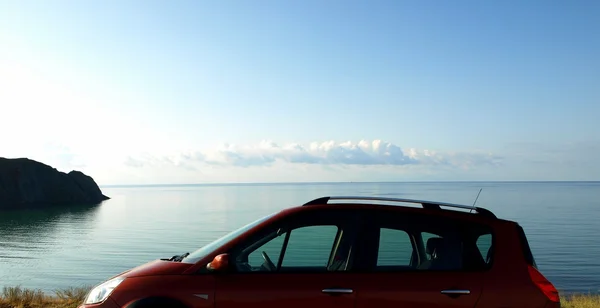 Outdoor car travel. Car on the sea beach at sunset