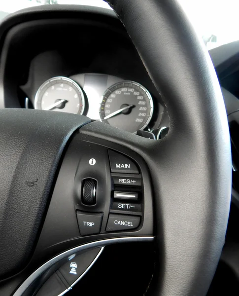 Car interior. Dashboard and controls on steering wheel