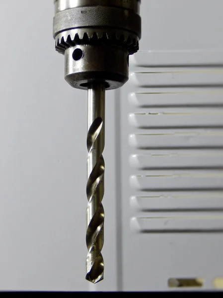 Head of drilling machine with metal drill bit close up