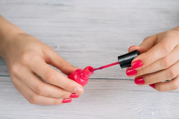 Women's hands painted nails with red lacquer