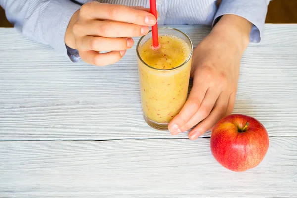 Woman drinks Smoothies from apples and celery in a glass with a