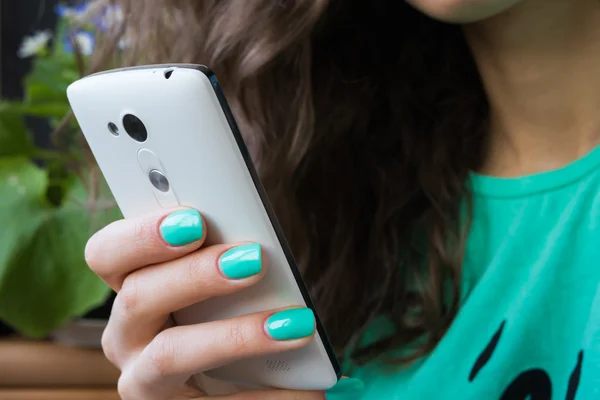 Female hand with bright manicure holding a mobile phone