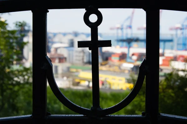 Silhouette of an anchor in the fence and sea port