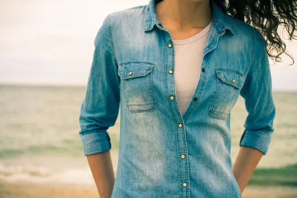 Denim shirt on a girl with curly hair close-up on a background o