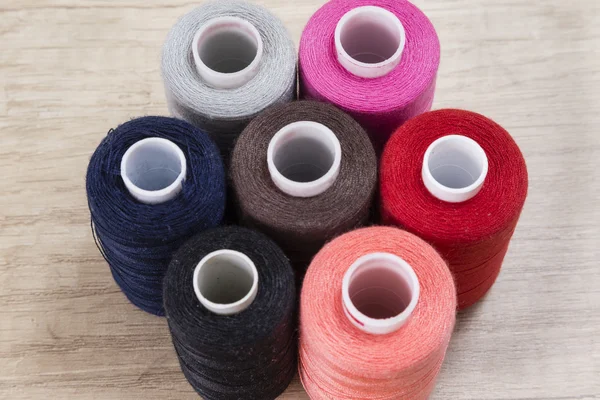 Several spools of thread of different colors and sizes