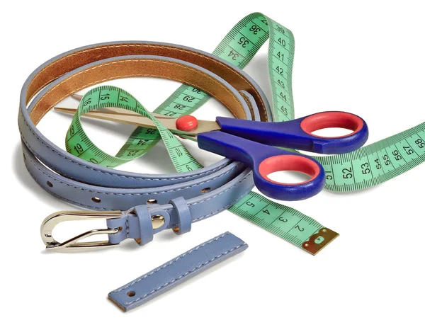 Waist belt, a pair of scissors and a tailor\'s ruler