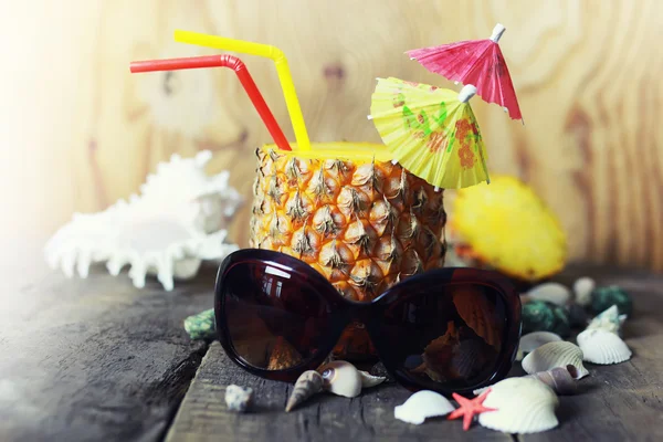 Pineapple with straw and cocktail umbrella