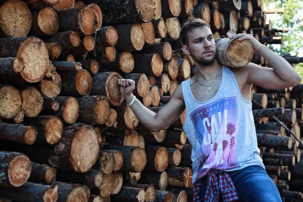 Bearded person near timber pile wood