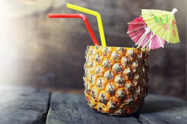 Pineapple with straw and cocktail umbrella