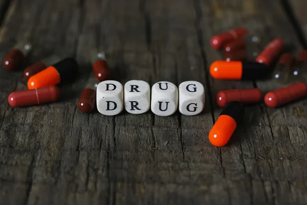 Drug pill on wooden table concept addiction