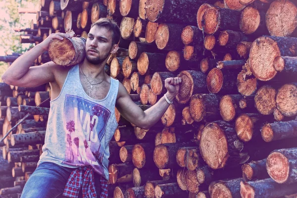 Bearded person near timber pile wood