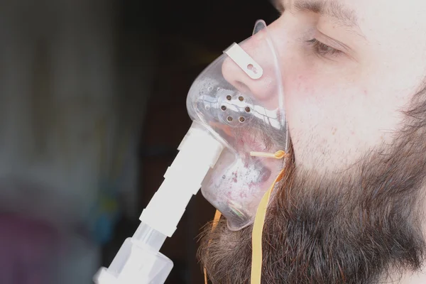 Bearded man with an asthma inhaler to breathe health