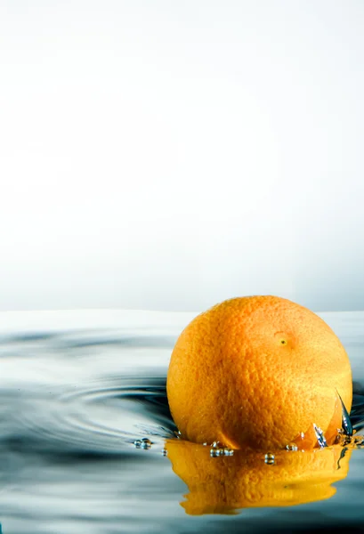Orange falling into water.