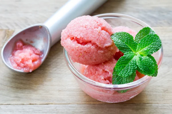 Homemade strawberry sorbet in glass and ice cream spoon