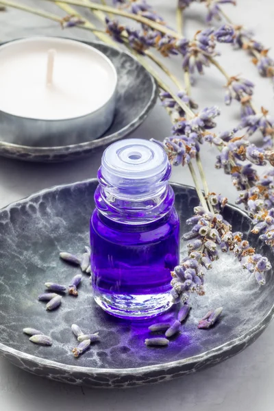 Lavender oil in a glass bottle. Vertical close-up