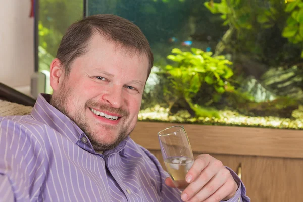 Man sitting in armchair with glass of champaign