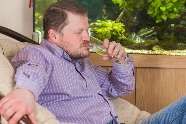 Man sitting in armchair with glass of champaign