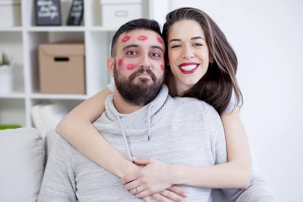 Woman kissing man with red lipstick