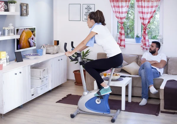 Woman training on exercise bike in room