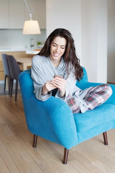 Woman on sofa using phone