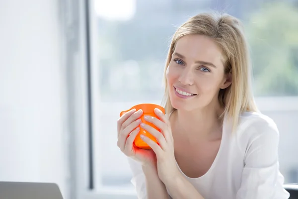 Blond businesswoman drinking coffee