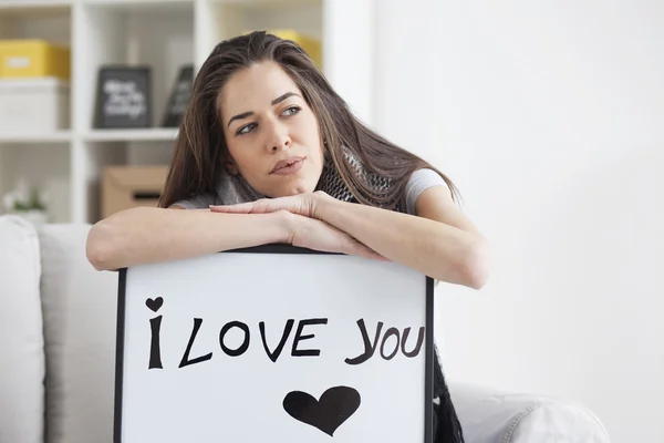 Woman holding white board with \'I love you\'