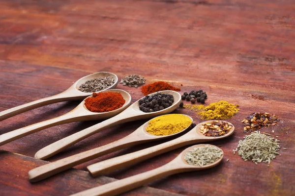 Wooden spoons full of herbs and spices