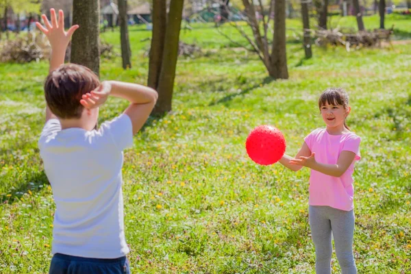 Boy and girl playing with ball in park