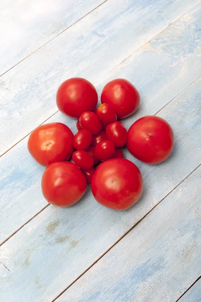 Red organic tomatoes on a blue wooden board
