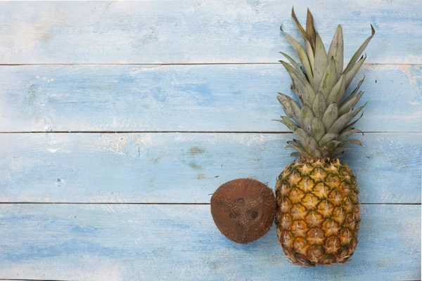 Coconut and pineapple on a blue wooden table