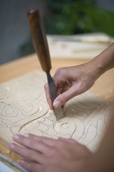 Wood carving on table with artist