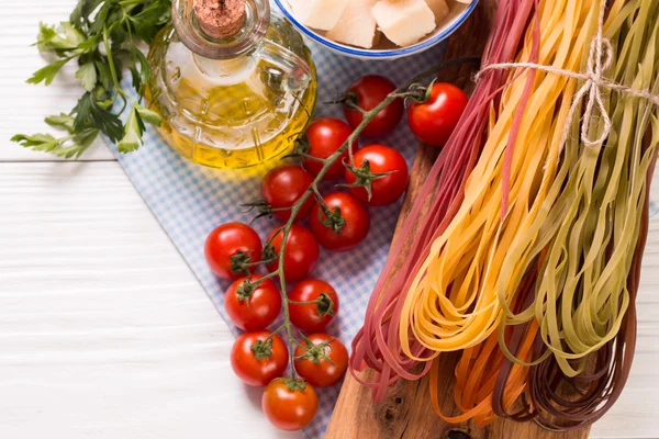 Vegetable color Pasta, oil,tomatoes,cheese on wooden table. italian food